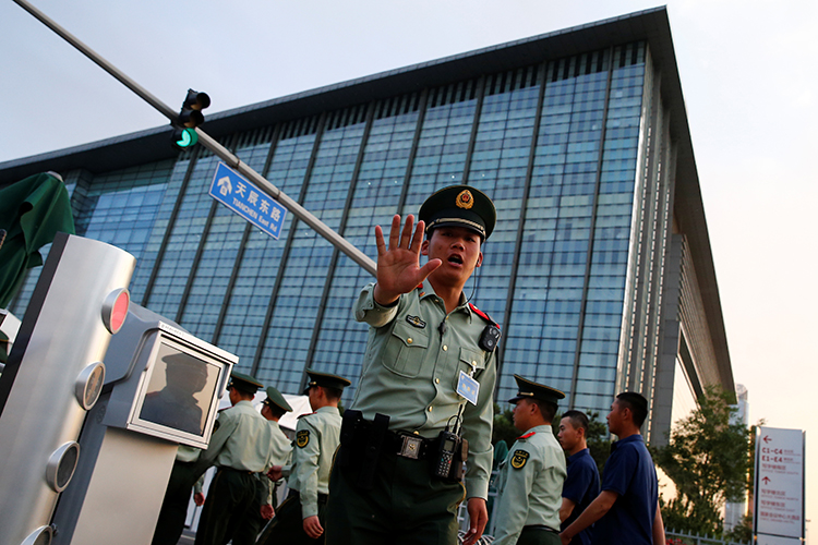 A policeman tells a photographer not take pictures, in Beijing, May 12, 2017. (Reuters/Thomas Peter)