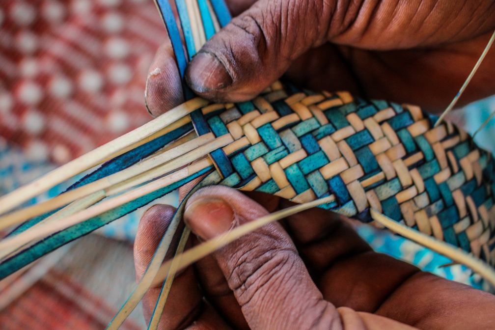 A Malian refugee artisan weaves a palm mat at the workshop. UNHCR / Paul Absalon