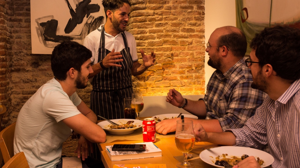 Refugee chef Mohammed greets customers at l'Artisan restaurant, in Madrid. Photo by Jane Mitchell.