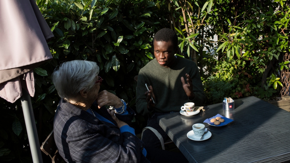 Emmanuel talks with Anna Illy at a cafè in in Duino. Anna donated him a full scholarship to attend the Adriatic College.
