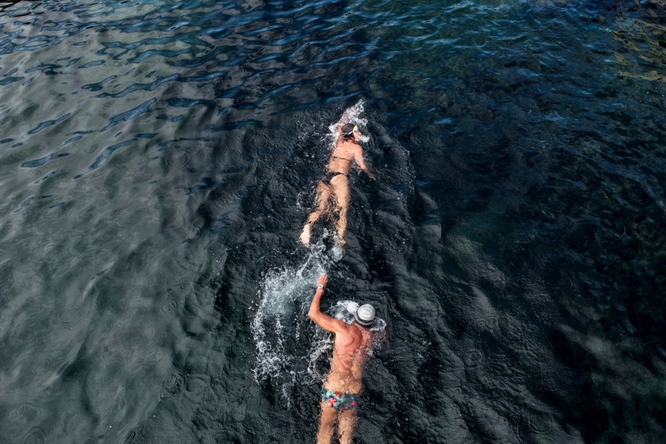 Two swimmers pass by La Buvette des Bains restaurant on Lake Geneva.
