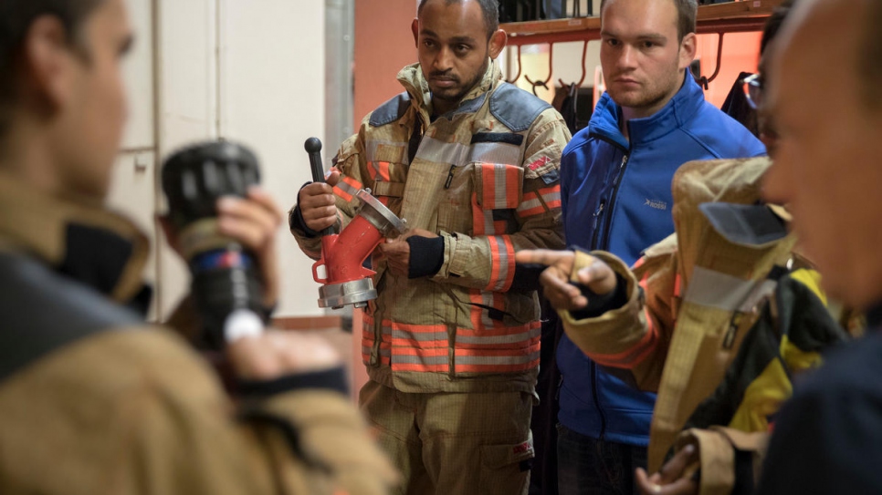 Yusuf listens to the team briefing. Before he can go on his first real rescue or firefighting mission, he must pass more exams and improve his German