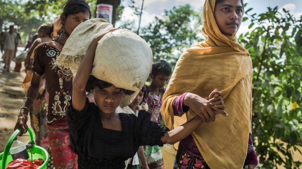 Eighteen-year-old Rabiaa Khatun and her niece, Umme Salma, 8, walk 10 kilometres from the Myanmar border to a UNHCR transit camp in Kutupalong, Bangladesh. 