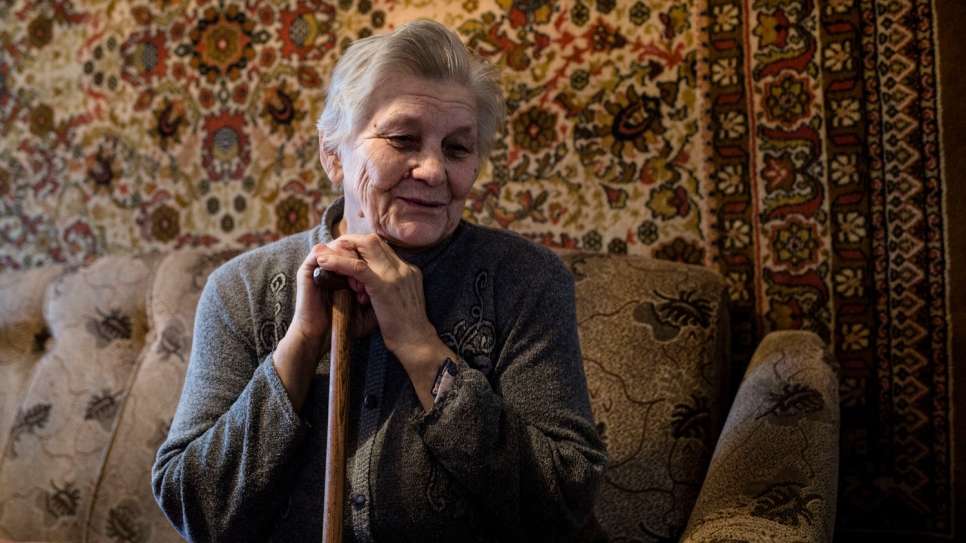 Hanna sits in her living room. She has stayed with her sick husband since the war began in eastern Ukraine in April 2014.