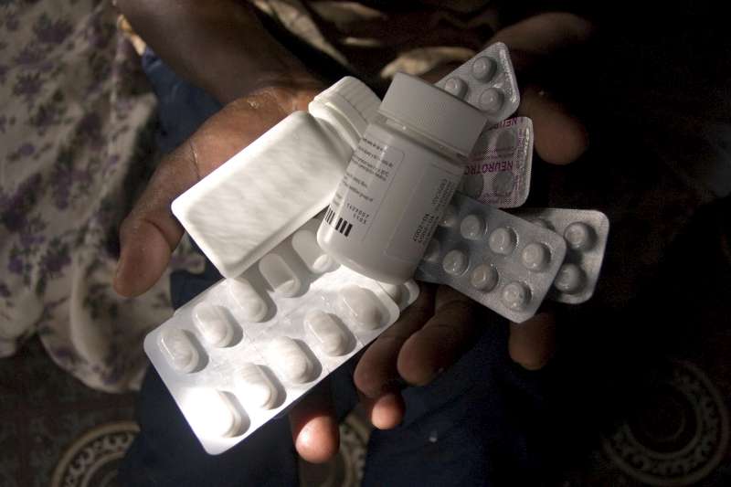 An HIV positive woman in Kakuma refugee camp, Kenya, holds out the variety of different medicines and ARV's she takes everyday.