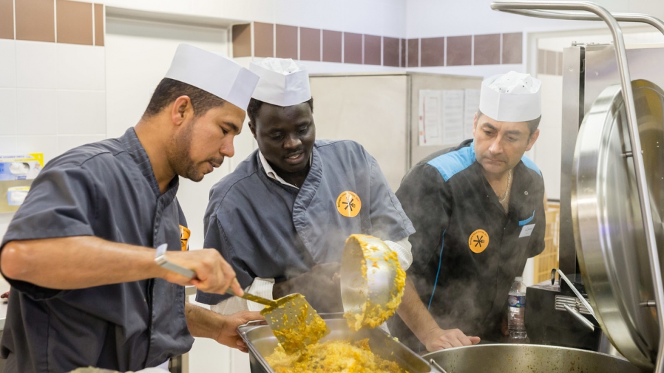 Saber Hajaj (gauche), un chef réfugié yéménite, cuisine avec l'interprète soudanais Ahmed Tibin (centre) et le chef français Samuel Lebouc, de la cantine du collège Louis Pergaud, lors du Refugee Food Festival dans les collèges du Calvados. Pour la première fois, le Refugee Food Festival se déroule dans quatre écoles normandes,  à l'occasion du Prix Bayeux-Calvados pour les correspondants de guerre, en octobre 2017. Cet évènement gastronomique est une initiative citoyenne co-organisée par l'association française Food Sweet Food et le HCR. Pendant une semaine, trois chefs réfugiés yéménite, syrien et iranien mijotent des plats traditionnels pour 1 500 élèves dans quatre écoles du département du Calvados. 