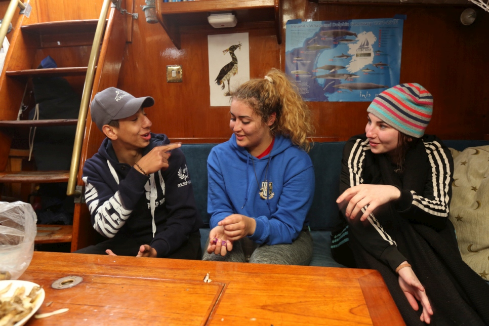 Des adolescents discutent dans la cabine, à bord de la goélette Spirit of Oysterhaven.