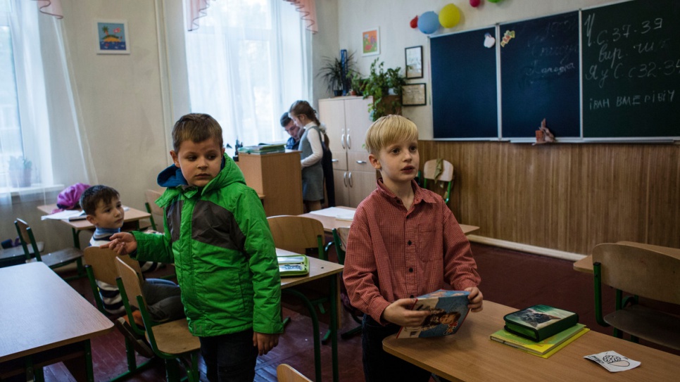 Igor (L) arrives at school with his mother to pick up Ivan (R).