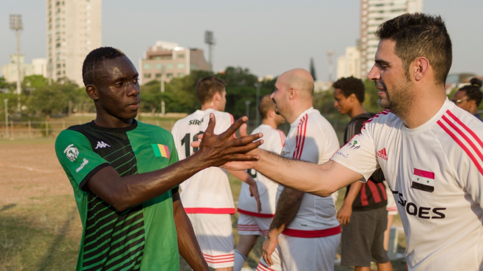 Syrian and Malian players shake hands after their Refugees World Cup game in CERET Park, Sao Paulo, Brazil.