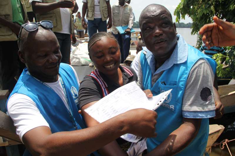 UNHCR staff help refugee returnees coming off the boat at Buburu in Democratic Republic of the Congo's Equateur province. 