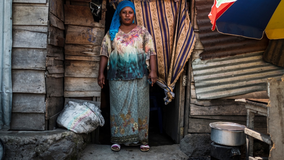 Odette stands at the door of her restaurant in Goma.