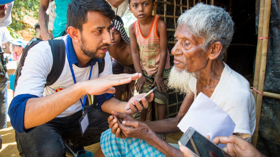 Un volontaire du HCR recueille des informations auprès de Mohammad Busho, 80 ans, au site d'extension du camp de Kutupalong, Bangladesh. Les données permettent d'accélérer l'aide aux familles réfugiées dans le besoin. 