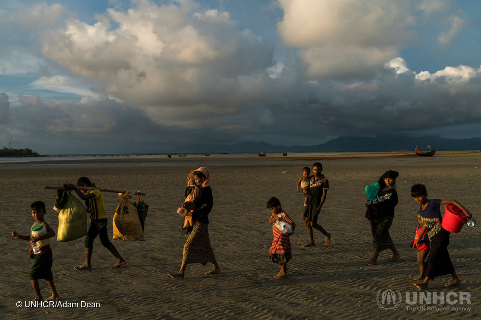 Rohingya-familier går over stranden ved Dakhinpara, Bangladesh, efter at have krydset havet fra Myanmar ombord på fiskerbåde. © UNHCR/Adam Dean