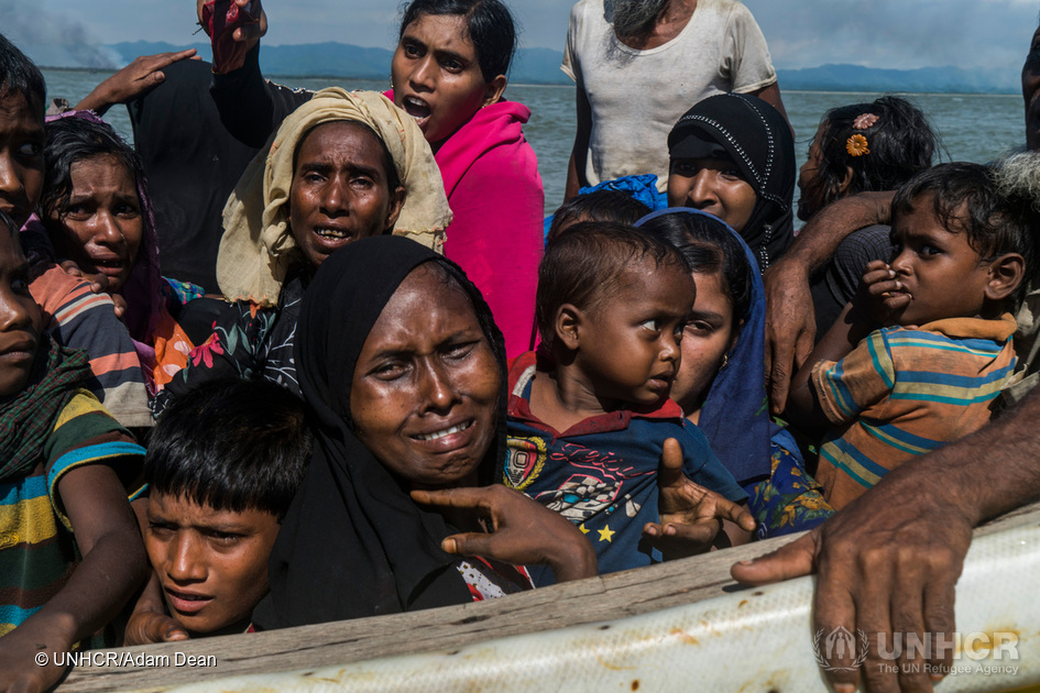 Rohingya-kvinder og -børn kryber sammen på en fiskerbåd, der nærmer sig stranden ved Dakhinpara, Bangladesh. © UNHCR/Adam Dean