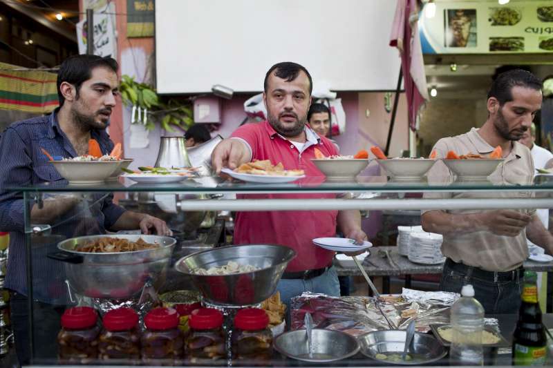 Day 6: Syrian chef, Galal (centre), prepares the evening iftar meal during Ramadan at the busy Bab Elhara Restaurant in Cairo. "I've worked in several restaurants in Syria and Saudi Arabia and I love cooking," he reveals, adding that his father cooked for an ambassador in Syria and taught 35-year-old Galal how to cook. "The first dish he taught me to cook is kibbeh [a Levantine dish made from bulgar, minced onions and ground meat], which is important not only during Ramadan - it's the jewel of any dinner." But Galal lost his job a year ago when things got worse in Damascus and restaurants began shutting down. He fled to Egypt a month ago with his wife and two children. The thing he misses most about Ramadan in Syria is getting together with his whole family. "I was away from Syria for eight years of my own free will in Saudi Arabia and Qatar, but now I'm away forcibly. As soon as things calm down, I will go back home."