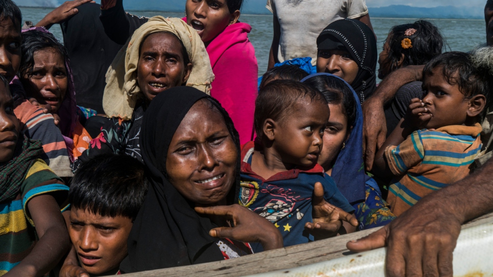 Rohingya women and children huddled on a fishing boat approach the beach at Dakhinpara, Bangladesh.