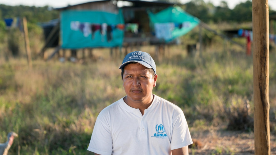 L'employé du HCR Harold Juajibioy Otero est assis devant la maison d'une famille à Villagarzón, dans l'installation de la communauté Awá. L'Agence des Nations Unies pour les réfugiés soutient l'autonomisation des communautés et la reconstruction du territoire autochtone. 
