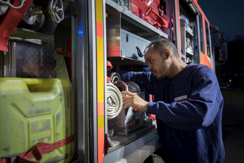 صورة: يوسف يتحقق من المعدات في شاحنة إطفاء. يأتي رجال الإطفاء المتطوعون أمثاله إلى المحطة في فورستنوالدة من أجل الخضوع للتدريب مرة واحدة في الأسبوع.
