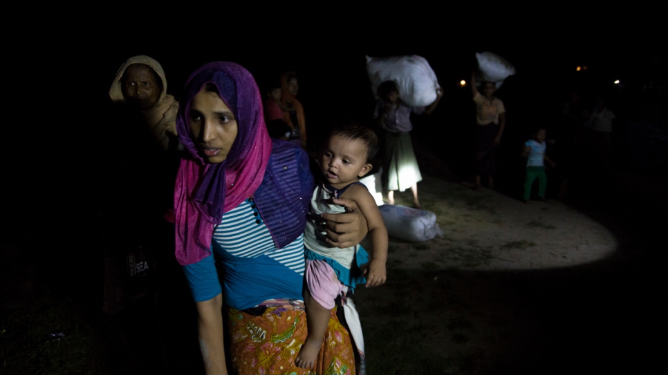 Des réfugiés rohingyas fuyant le Myanmar arrivent sur la plage de Shah Porir Dwip, près de Cox's Bazar, au Bangladesh, à bord d'un bateau de bois, sous couvert de l'obscurité. 