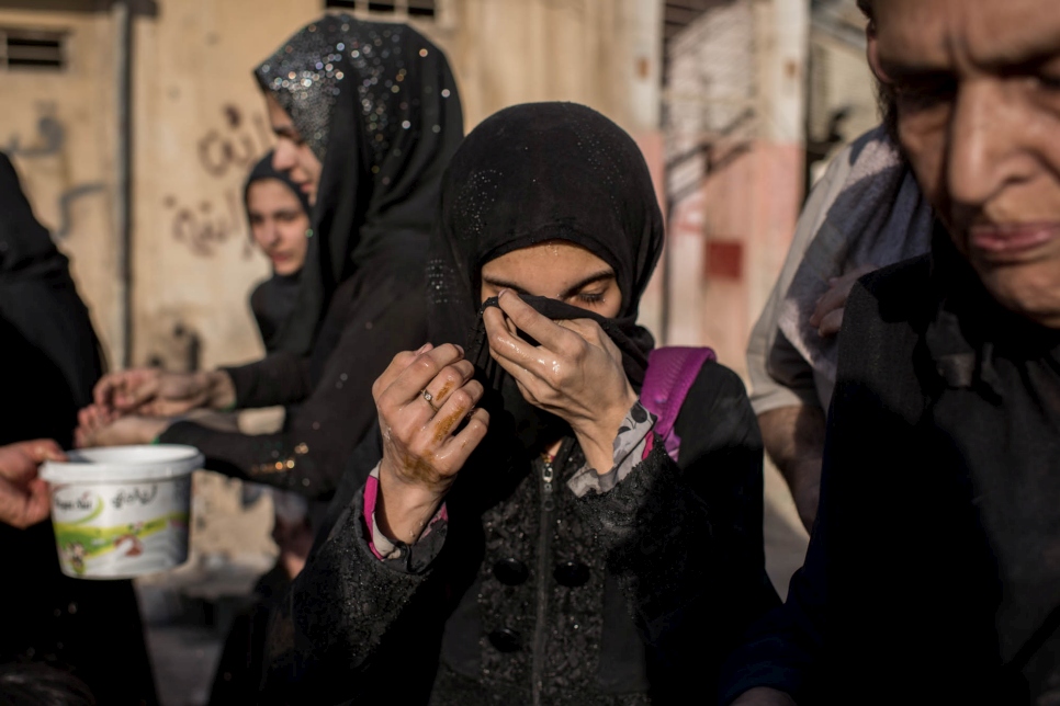 Une jeune Iraquienne se lave le visage après avoir atteint la zone contrôlée par les forces gouvernementales iraquiennes à Mossoul, le 23 juin 2017. 