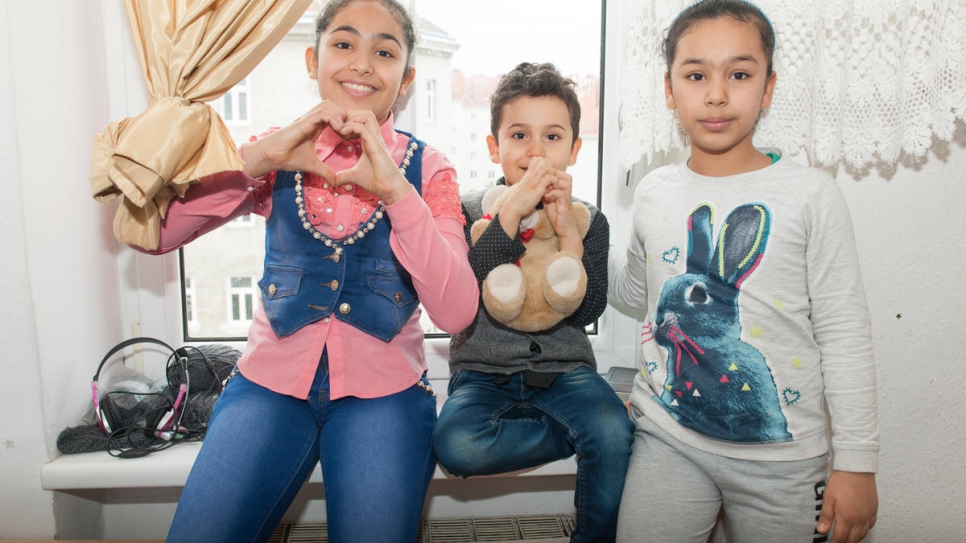 Trois des enfants de la famille Al-Bashawat (de gauche à droite) Fatima, Ali et Amal en train de s'installer dans leur nouveau logement après avoir retrouvé leur père à Vienne. 