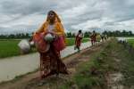 Senwara, a Rohingya refugee, cries as she arrives in Whaikhyang, Bangladesh, after walking two days from Myanmar with her father and son.