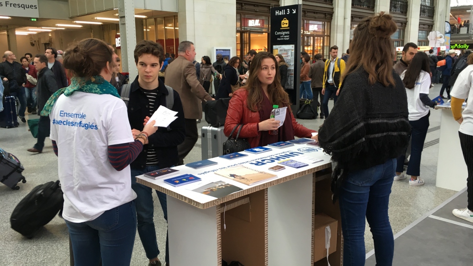 Des volontaires du HCR exliquent aux voyageurs de la Gare de Lyon, à Paris, quelle est la situation des réfugiés dans le monde et des déplacements globaux.