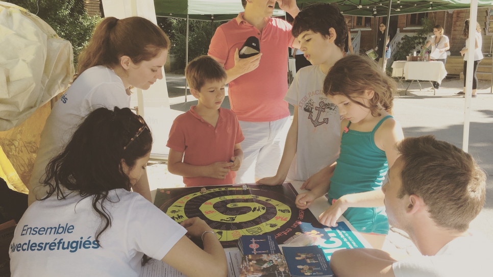 Des bénévoles du HCR expliquent aux familles qui participent au Good'Week-end Réfugiés d'Ici et d'Ailleurs   à la Fondation GoodPlanet – Domaine de Longchamp la situation des réfugiés dans le monde grâce à un quiz et un jeu de l'oie pour enfants.