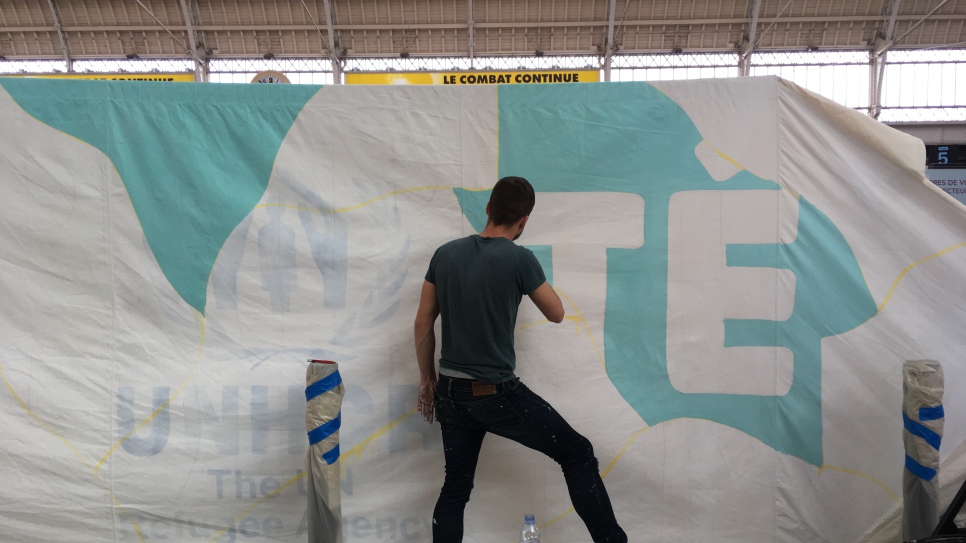 Seb Toussaint, un artiste franco-anglais qui dessine des graffitis sur les murs de camp de réfugiés à travers le monde, écrit le mot "liberté" sur une tente du HCR, à la Gare de Lyon, le 25 octobre 2017. Son projet "Share The Word", en collaboration avec d'autres photographes, consiste à peindre une fresque basée sur le mot que des personnes issues de communautés vulnérables, souhaitent exprimer. 