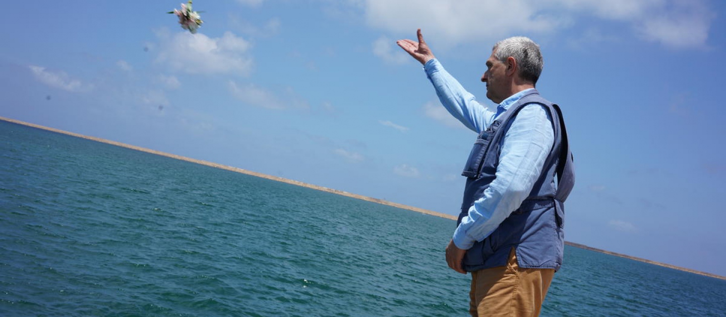 El Alto Comisionado de las Naciones Unidas para los Refugiados Filippo Grandi arroja al mar un ramo de flores en Abu Setta, Libia, antes de pedir un minuto de silencio para rendir homenaje a los miles de personas refugiadas y migrantes que fallecieron en el mar en el intento de llegar a Europa.