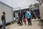 Refugees and migrants arrive at a registration center in Greece after ...