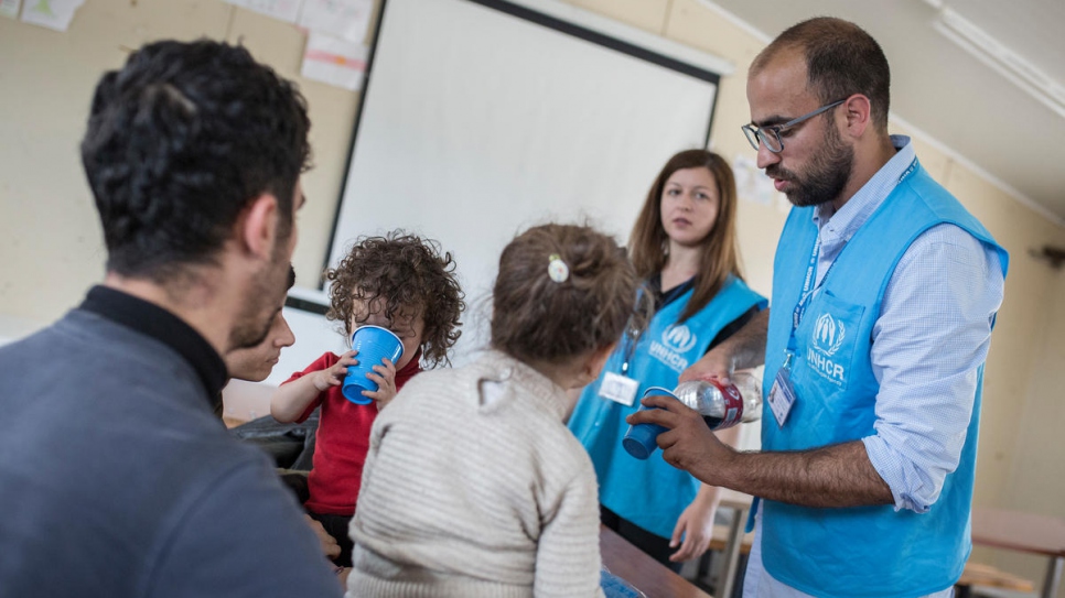 Le personnel du HCR accueille des réfugiés et des migrants dans le centre d'accueil de Fylakio. 