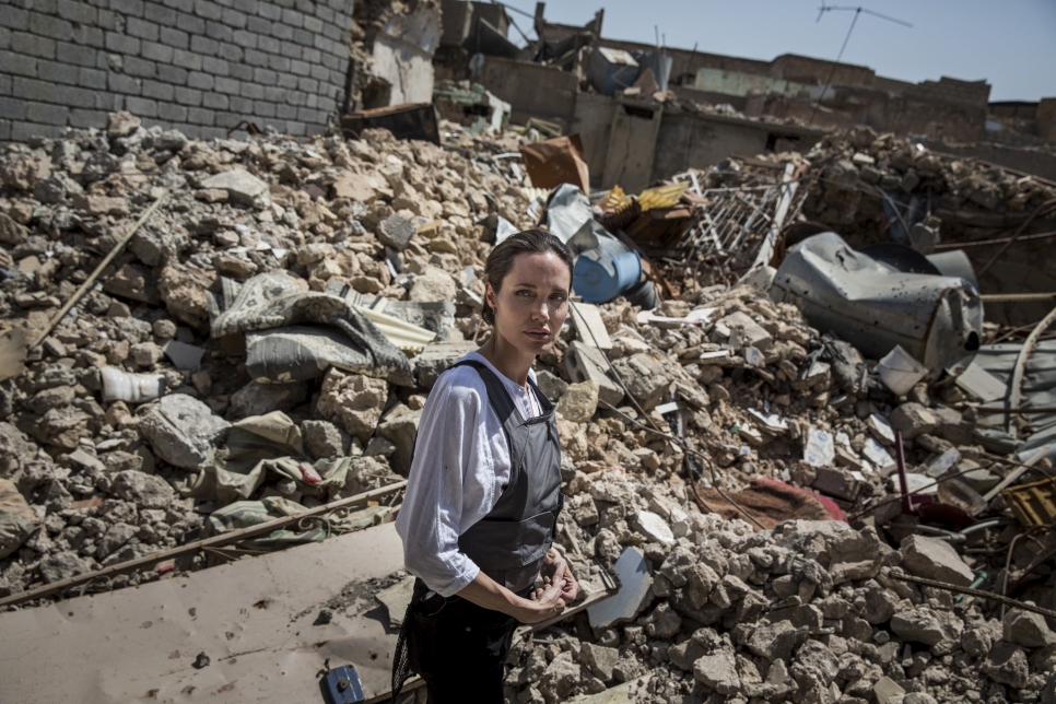 L'Emissaire du HCR Angelina Jolie lors de sa visite dans la vieille ville de Mossoul-Ouest en Irak. Les habitants lui ont expliqué que les cadavres de plusieurs militants se trouvent encore sous les décombres derrière elle. La couverture rouge couvre des munitions non explosées.  