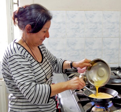 Anahid, refugiată din Iraq de origine armeană pregătește micul dejun în bucătăria comună de la ETC. Foto: UNHCR/G.Leu