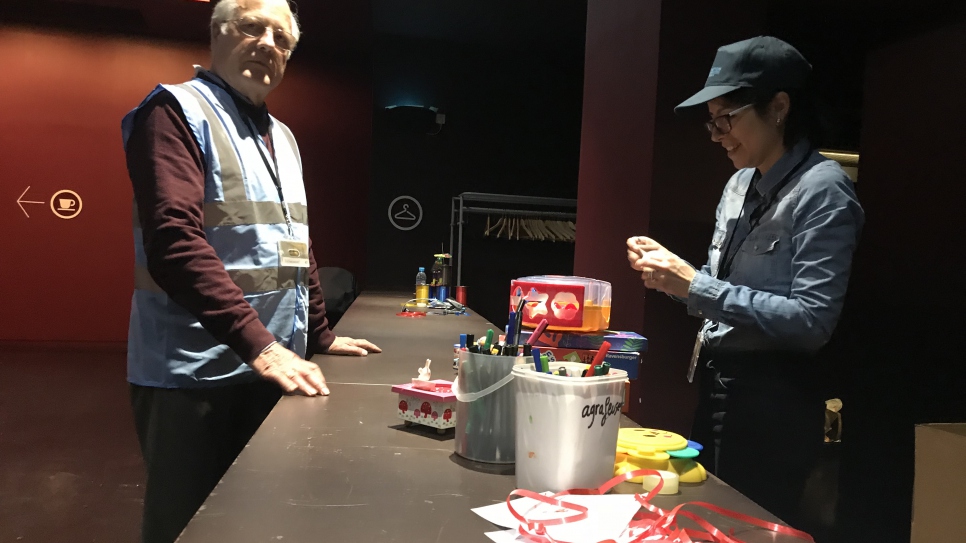 Daniel Loubery, Responsable du fret humanitaire chez Aviation Sans Frontières se tient, avec sa collègue, devant le stand du Musée du Quai Branly à Paris, où les enfants donnent des jouets pour des enfants réfugiés syriens au Liban, le 27 décembre. Cette année, l'organisation humanitaire acheminera 23 cartons de jouets. Elle organisera et prendra en charge le coût du transport aérien. 
 