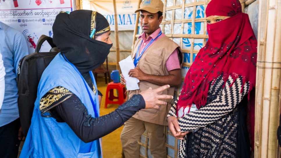 Nur Bahar, 30, a UNHCR Community Outreach Member, counsels Shamshidah at an Information Point in Kutupalong refugee settlement.

