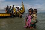 A mother carrying her child wades towards the beach at Dakhinpara, Bangladesh.