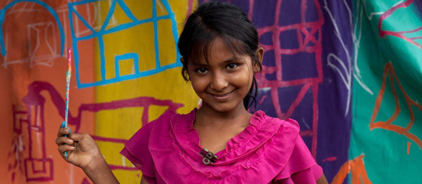 Bangladesh. A child painting a UNHCR tent