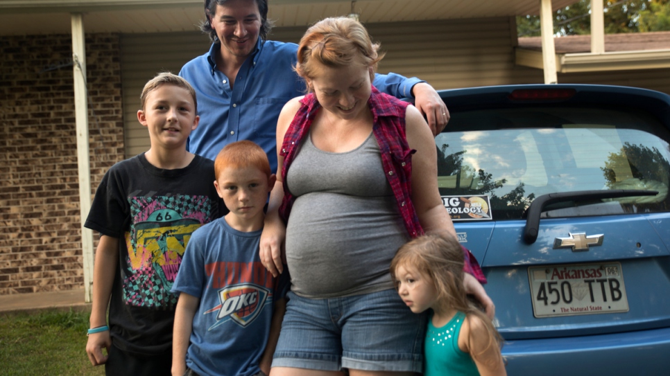 Cobi Cogbill and his wife, Leanda, stand in front of their house in Fayetteville, Arkansas, with their three children. They are expecting a baby boy in November. Cobi credits Leanda with helping change his views on refugees and immigrants.