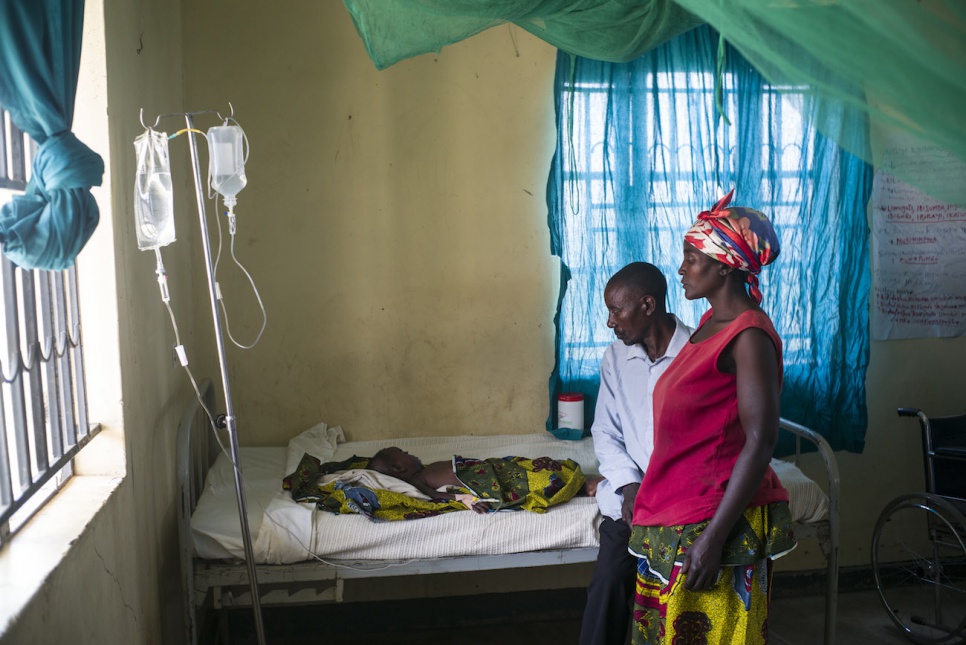 Janette and John watch over their 18-month-old daughter, Agness, who has been diagnosed with malaria.
