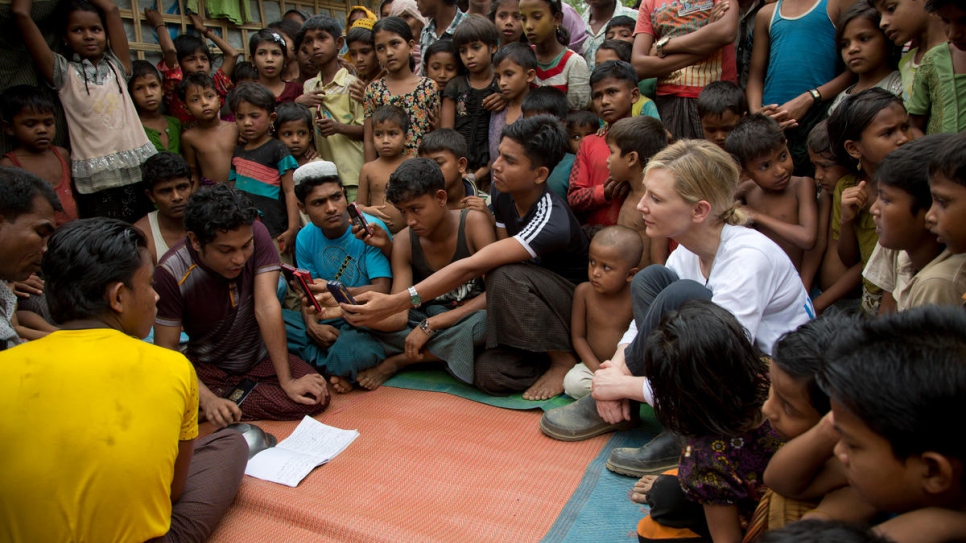 Cate Blanchett watches a performance by Rohingya refugee Mohammed Sayidul Islam (left, purple t-shirt) and other musicians at Kutupalong refugee settlement.