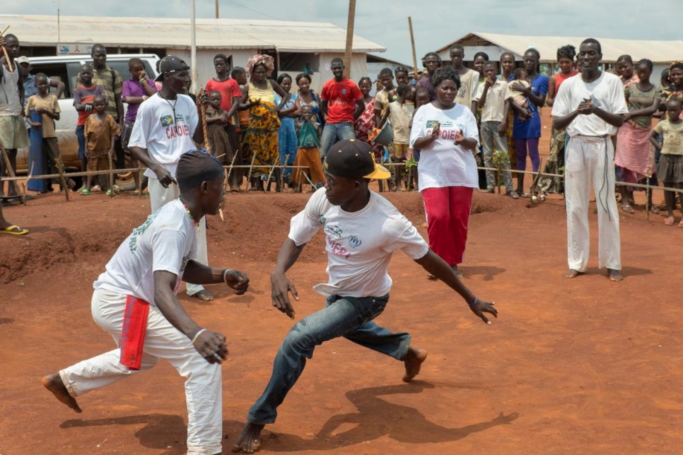 DRC / CAR Refugees / Central African refugees practice capoiera in front of an audience at Mole camp in Equateur Province, DRC on 21 August, 2014. Capoiera, originally a Brazilian sport which is a mix of music, dance and martial arts, was introduced in Mole two months ago as an organized leisure activity. Refugees quickly found that it offers not only good exercise, but that it brings people together in a way that contributes to peace building. / UNHCR / B. Sokol / August 2014