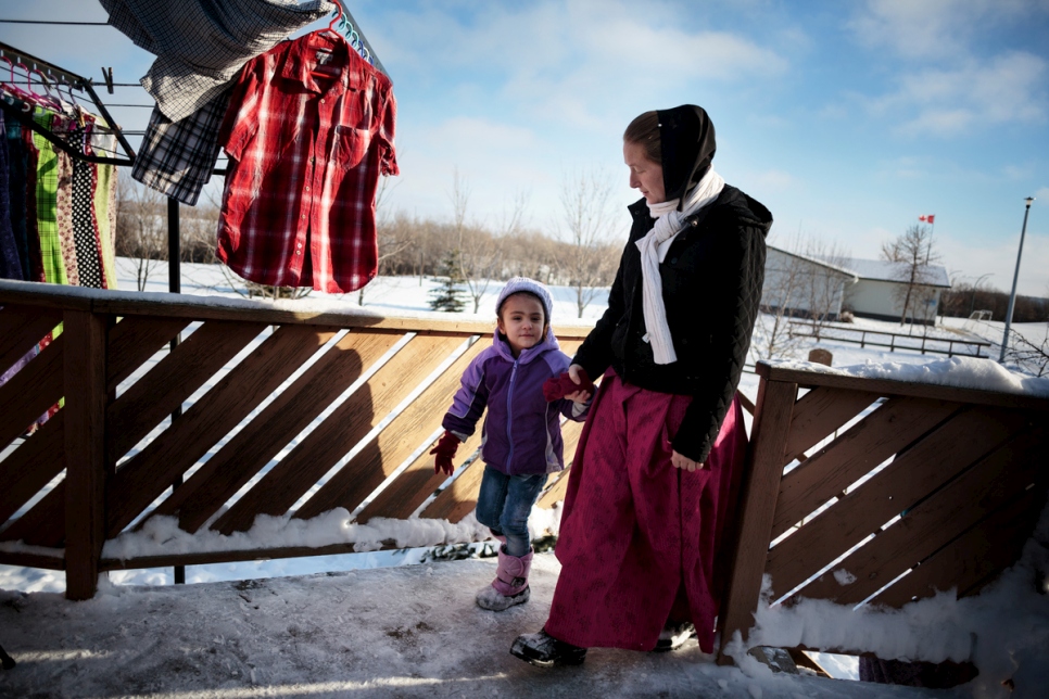 Elaine Hofer takes Raghad Al Hamoud back into the house to warm up after tobogganing with other children at the Hutterite colony.