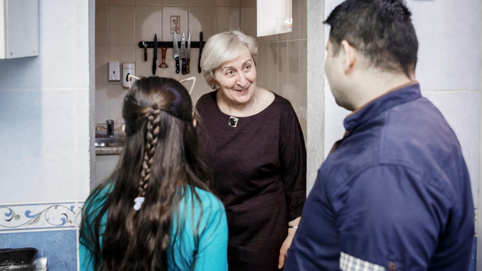 Marine Kolbaya, a former Georgian refugee, shows Imad Ahmad around the kitchen of her restaurant.