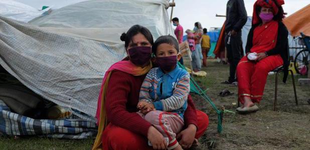 A mother and her child next to their tent in Ratna Park