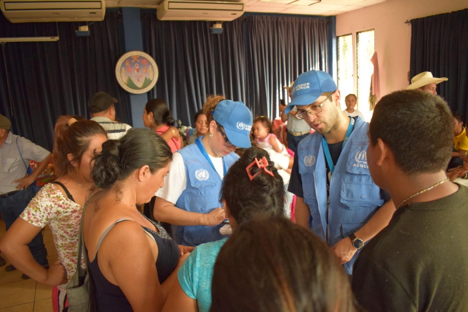 Des membres du personnel du HCR discutent avec des survivants après l'éruption du volcan de Fuego, au Centre universitaire du Sud (CUNSUR), qui abrite 214 personnes. 