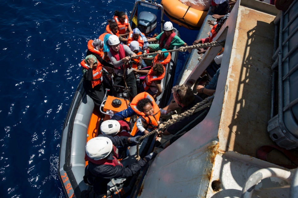 Crew from a Sea Watch search and rescue vessel rescue survivors from a boat that foundered trying to cross the Mediterranean to Europe from Libya in 2016.