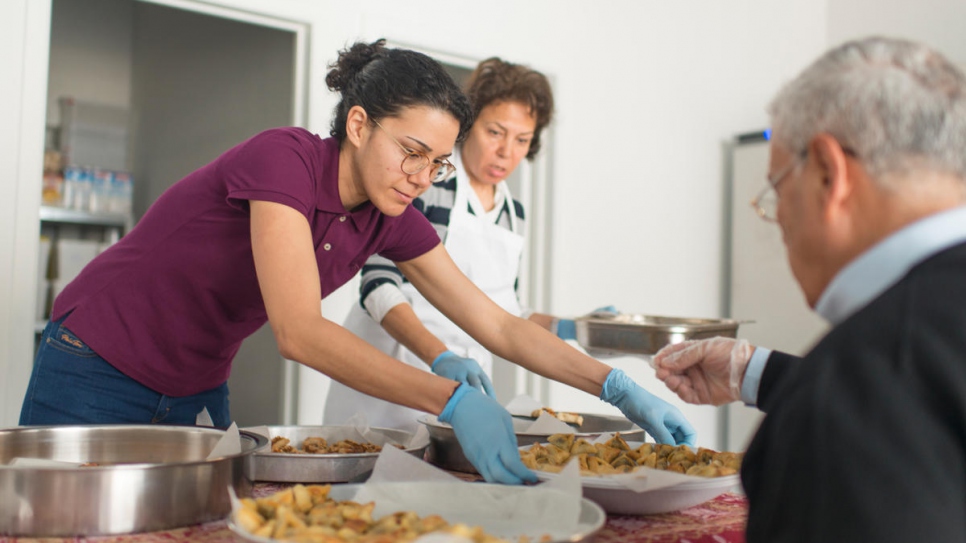 Yara Al Adib serves a guest at the launch of her catering company's first kitchen in Antwerp, Belgium.