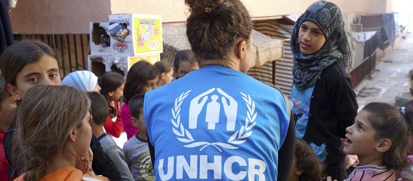 UNHCR's Christina Farah speaks with a group of children at the Nour Beach House in Chekka