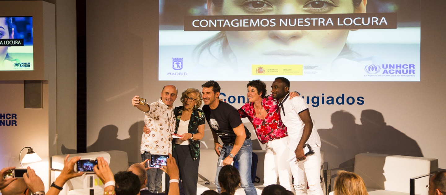 El presentador y los invitados al evento del Día Mundial del Refugiado 2018 en España se toman un selfie al final del evento.